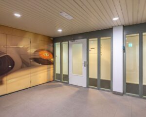 Entree van een kantoorruimte aan de Mozartlaan 27 in Hilversum met glazen deuren en een muurdecoratie met een platenspeler.