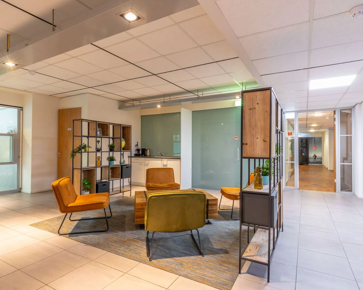 Moderne kantoorruimte met een loungegedeelte aan de Mozartlaan 27 in Hilversum, voorzien van zitmeubels, open kasten en een kitchenette.