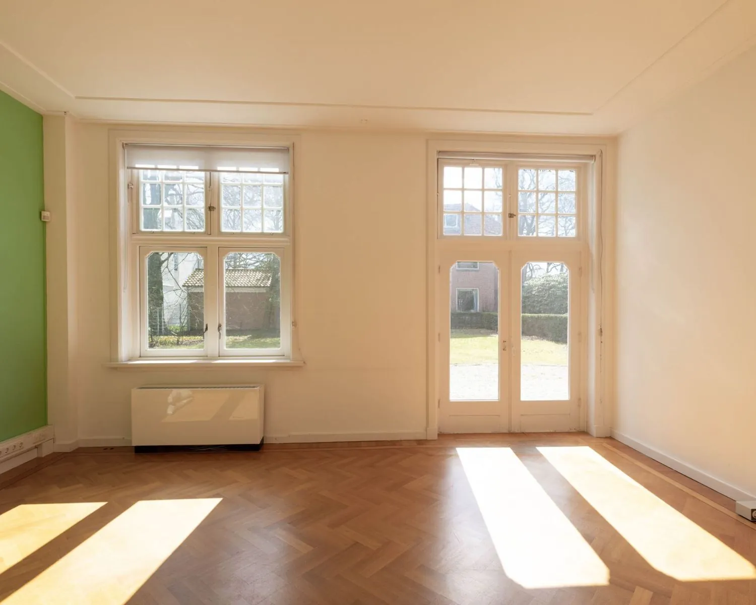 Lichte kantoorruimte met visgraatvloer en grote ramen aan de Utrechtseweg 47 in Hilversum.