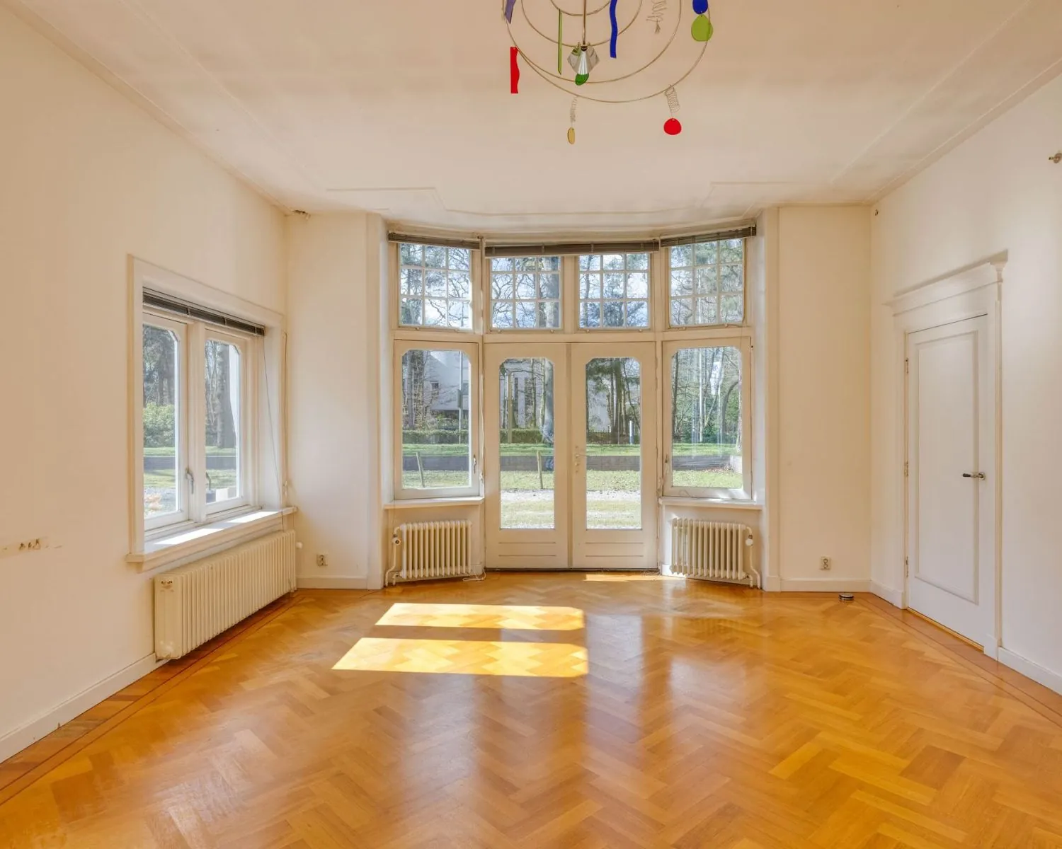 Lichte kantoorruimte met visgraatparket en grote ramen aan de Utrechtseweg 47 in Hilversum.