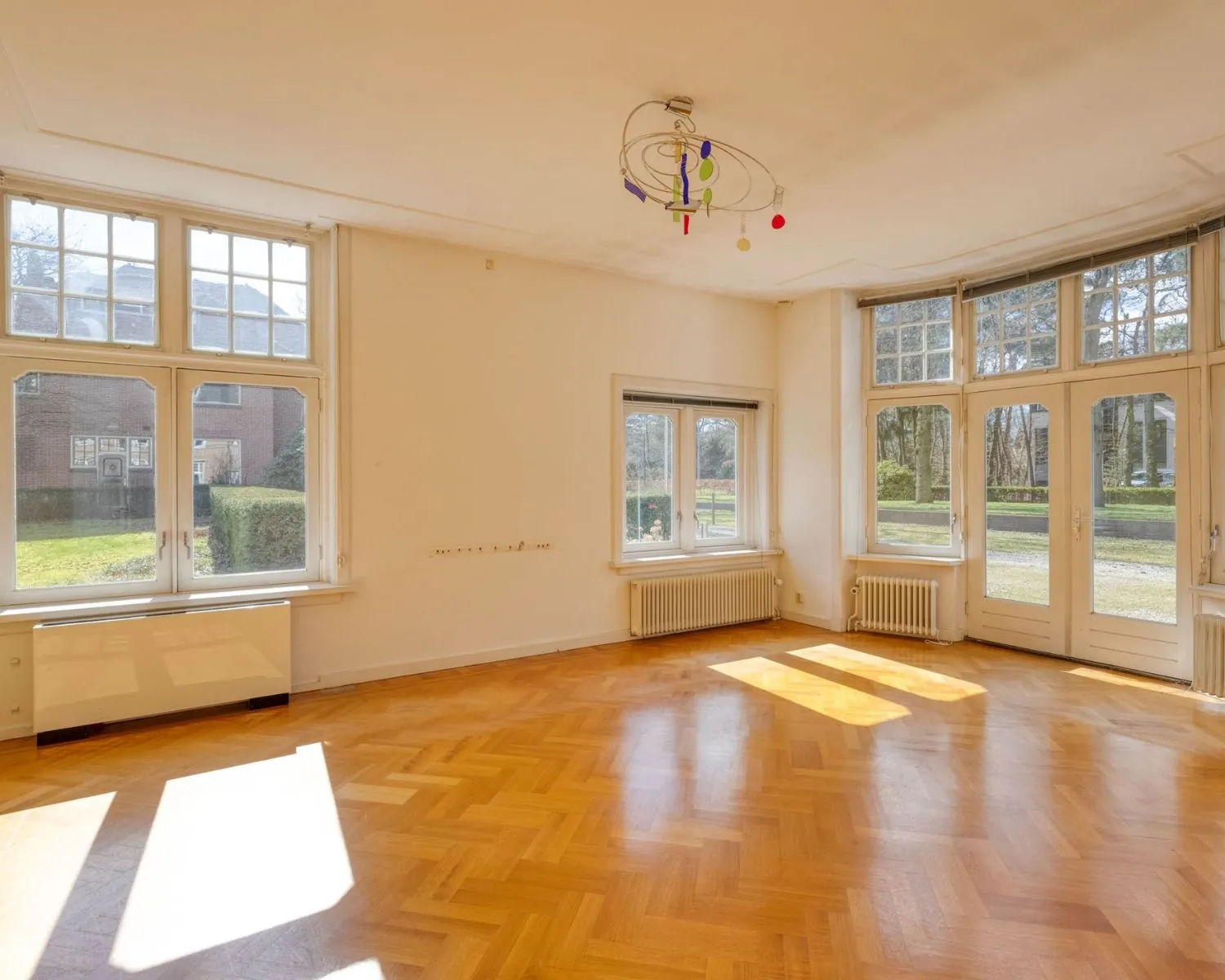Lichte kantoorruimte met grote ramen en parketvloer aan de Utrechtseweg 47 in Hilversum.