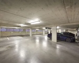 Ondergrondse parkeergarage bij kantoorruimte aan de Hogehilweg 24 met meerdere parkeerplaatsen en geparkeerde auto's.