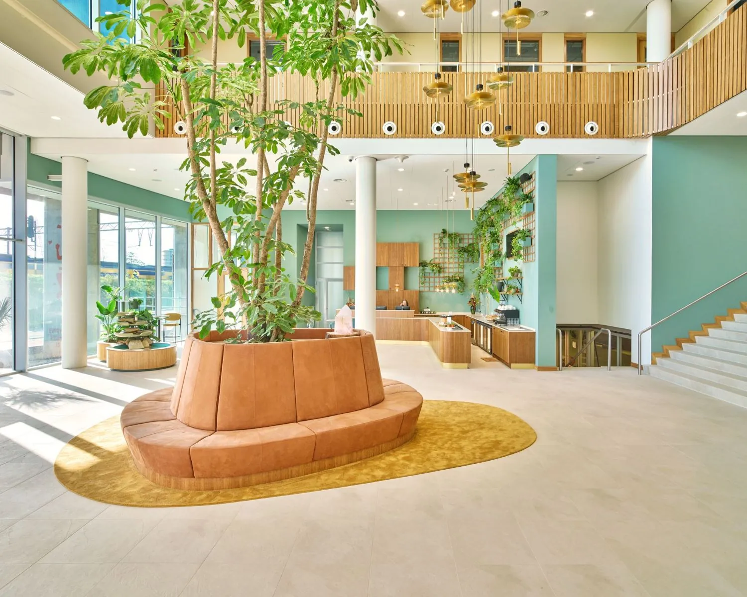 Moderne en lichte entreehal van een kantoorruimte aan het Mercuriusplein in Hoofddorp met groene planten, zithoek en houten accenten.
