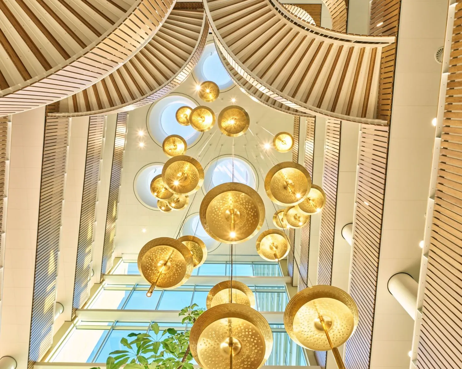 Moderne en lichte entreehal van een kantoorpand aan het Mercuriusplein in Hoofddorp met opvallende hanglampen en houten plafonddetails.