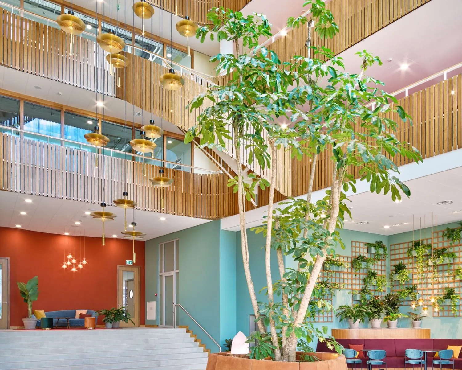 Moderne en kleurrijke kantoorruimte in Hoofddorp met veel planten, houten accenten en design verlichting.