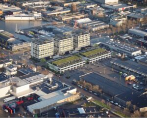 Luchtfoto van het kantoorgebouw aan de Jan van Krimpenweg 1-6 in een bedrijventerrein met water en omliggende bedrijfspanden.