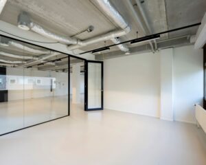 Moderne, lichte kantoorruimte met glazen wanden en zichtbare plafondleidingen aan de Joop Geesinkweg.