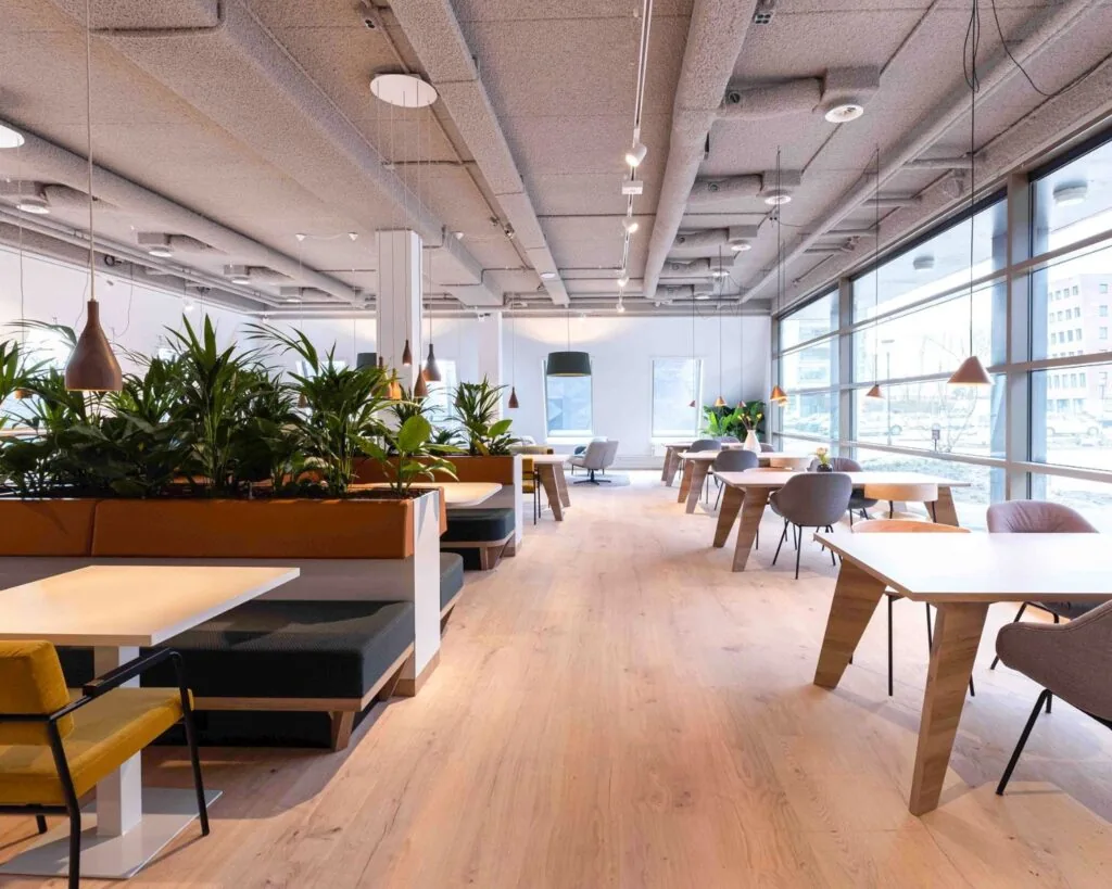 Moderne en lichte kantoorruimte met grote ramen, houten vloeren en diverse zitplekken aan de Joop Geesinkweg.