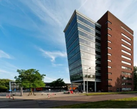 Modern kantoorgebouw aan de Joop Geesinkweg 201-224 met glazen gevel en bakstenen zijwand.