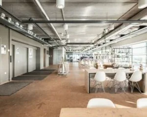 Moderne, lichte kantoorruimte aan de Joop Geesinkweg met open zitgedeelte, industriële plafonds en veel daglicht.