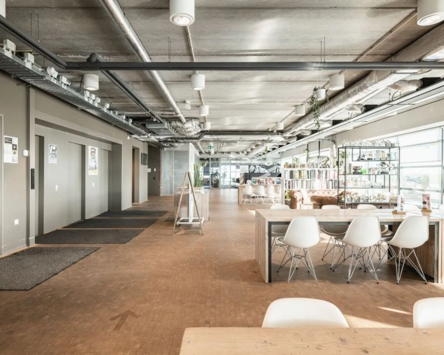 Moderne, lichte kantoorruimte aan de Joop Geesinkweg met open zitgedeelte, industriële plafonds en veel daglicht.
