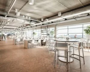 Moderne, lichte kantoorruimte aan de Joop Geesinkweg met open zitgedeelte en grote ramen.