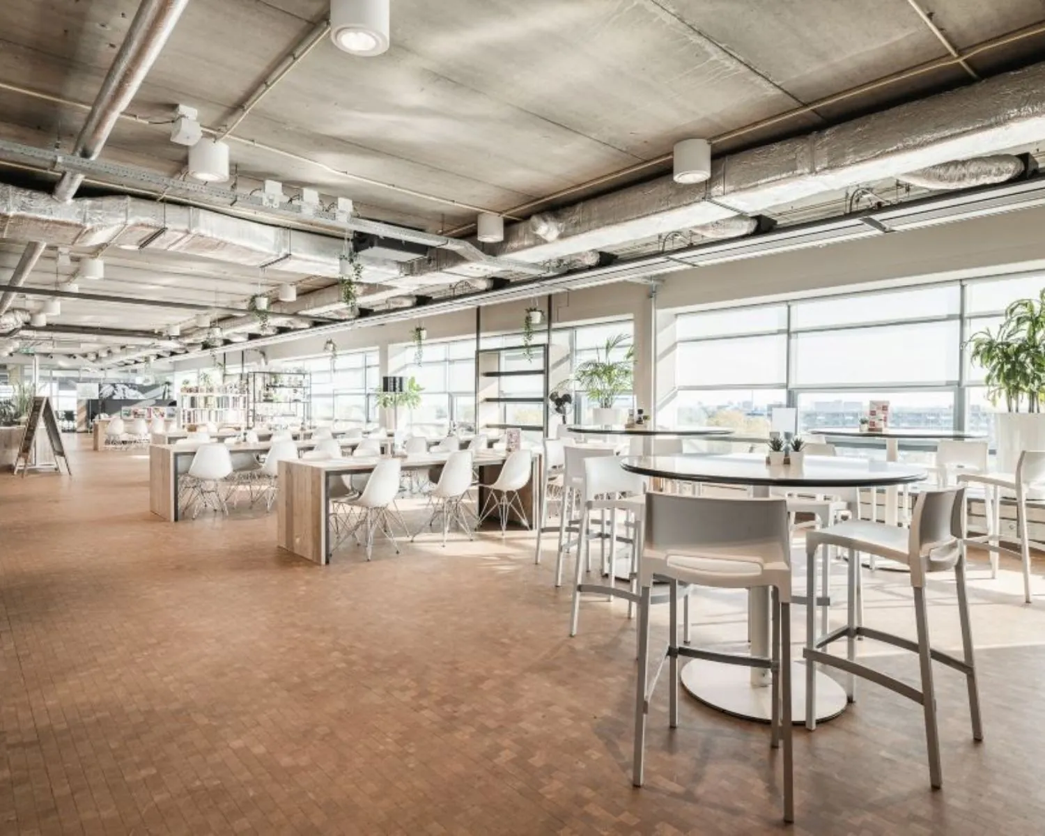 Moderne, lichte kantoorruimte aan de Joop Geesinkweg met open zitgedeelte en grote ramen.