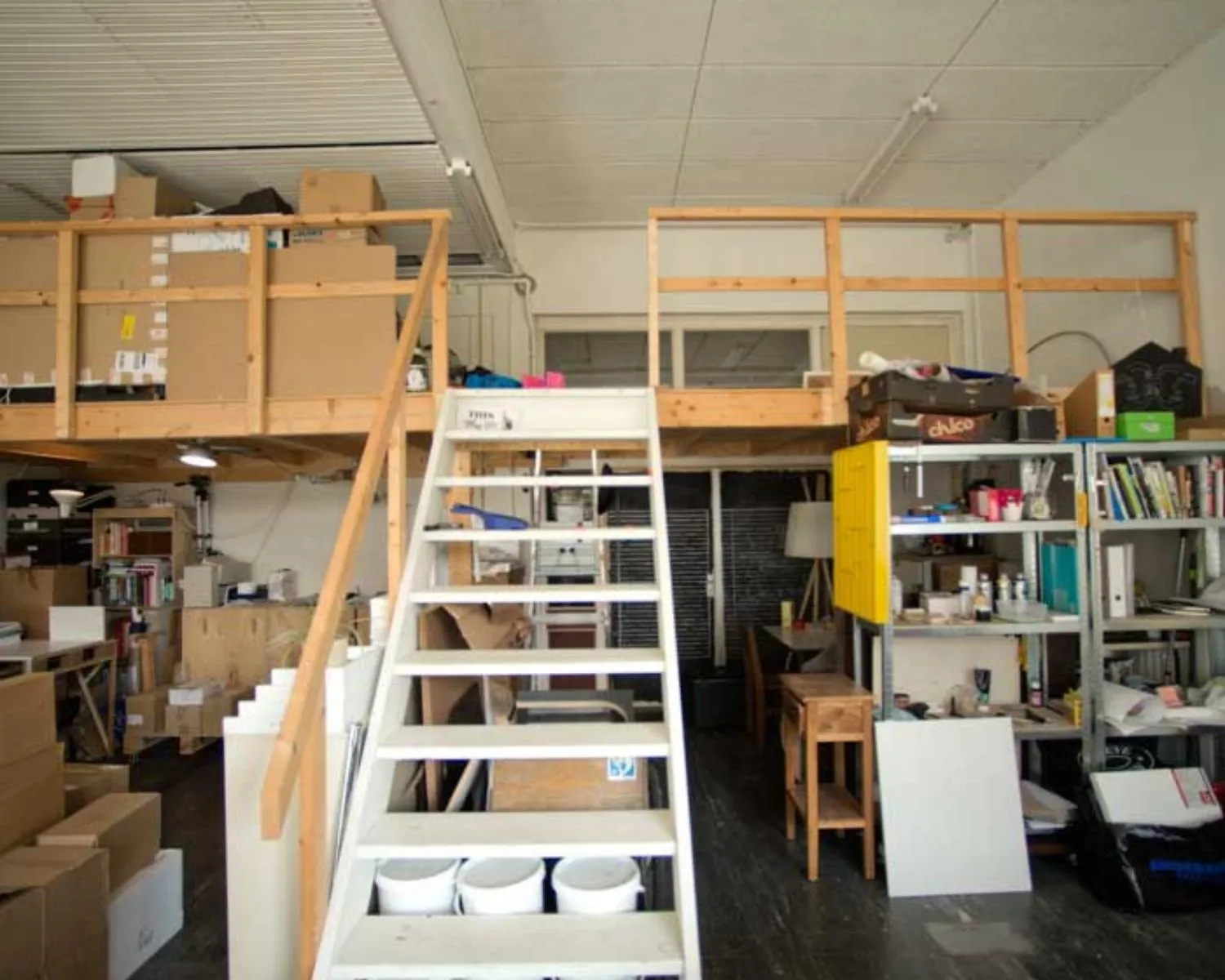 Industriële kantoorruimte met entresol, trap en opslagrekken aan de Krelis Louwenstraat.