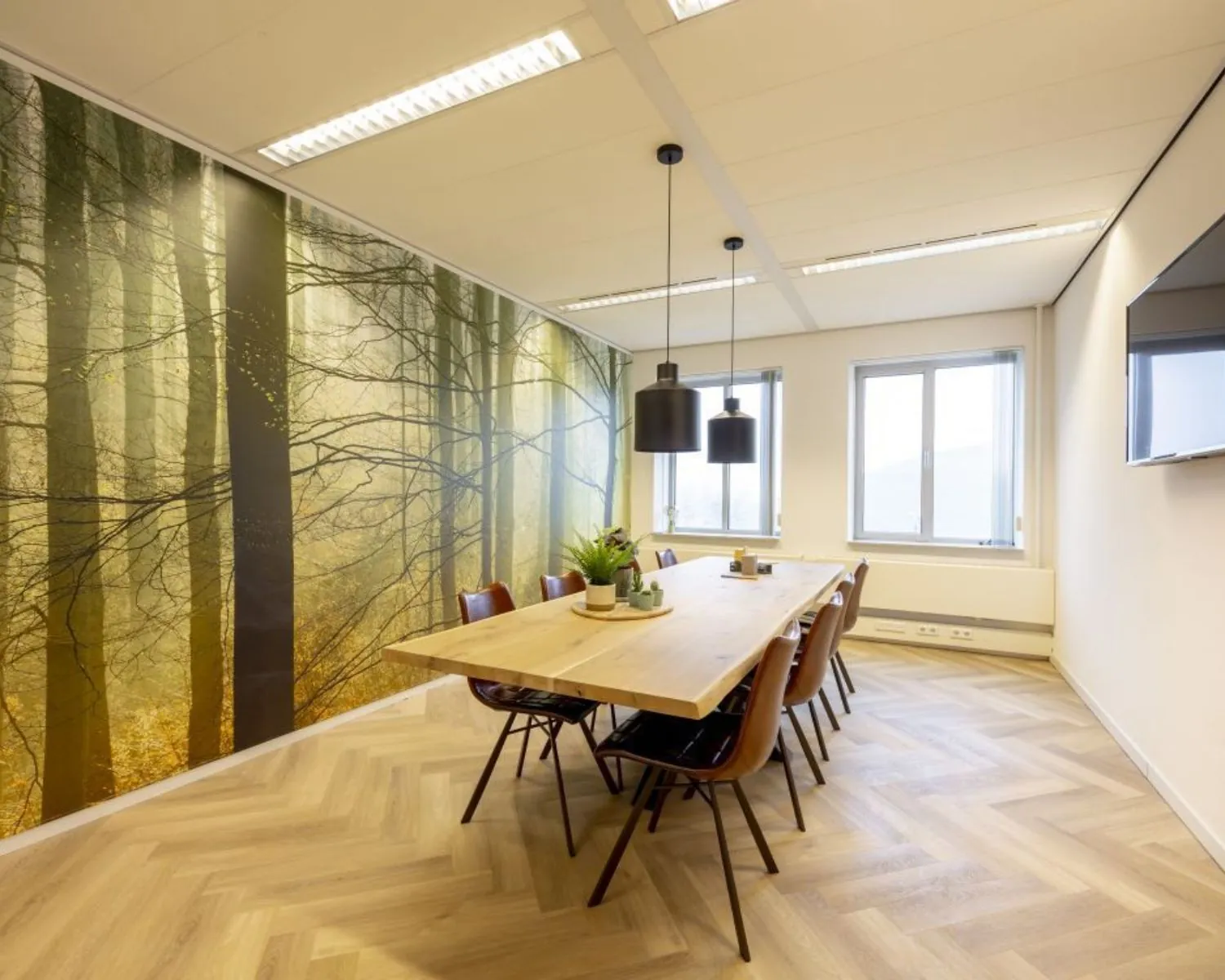 Vergaderruimte in Meander 901 te Arnhem met houten tafel, leren stoelen, natuurwandprint en veel daglicht.