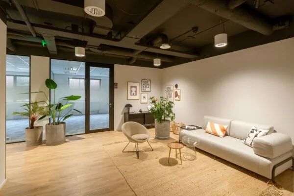 Moderne, sfeervolle wachtruimte in kantoorruimte Olympia 1-3 met designmeubels, planten en wanddecoratie.