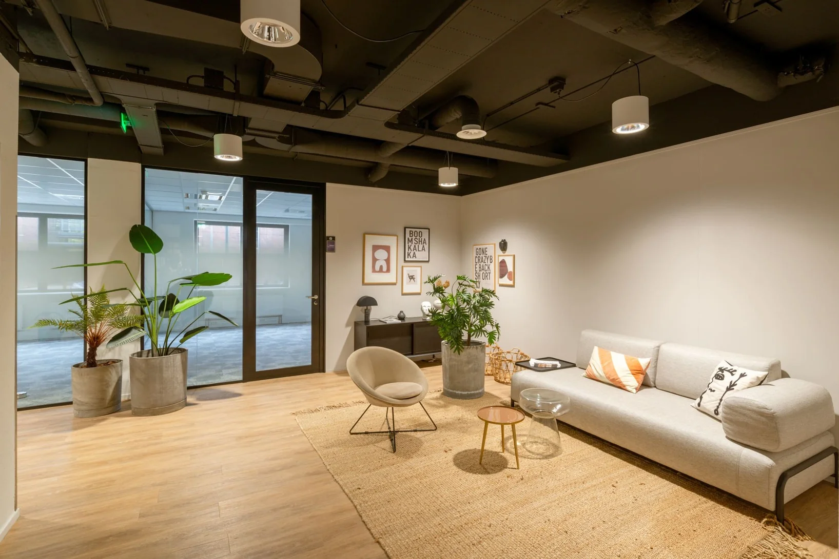 Moderne, sfeervolle wachtruimte in kantoorruimte Olympia 1-3 met designmeubels, planten en wanddecoratie.