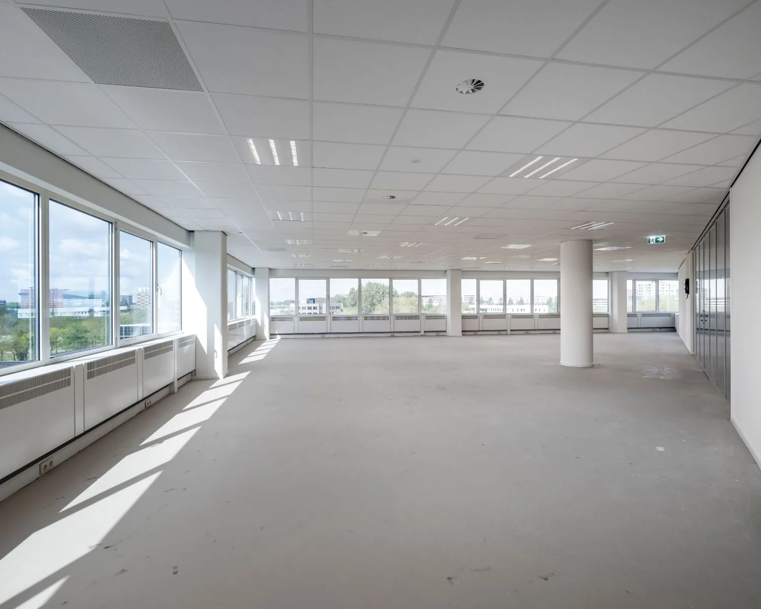 Lichte, open kantoorruimte te huur aan de Overschiestraat 61 met grote ramen en systeemplafond.