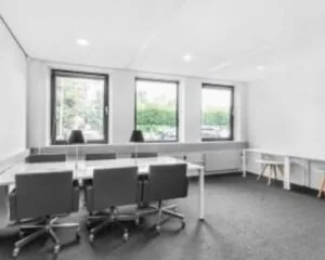 Moderne, lichte kantoorruimte met vergadertafel en bureaus aan de Paterswoldseweg 806.