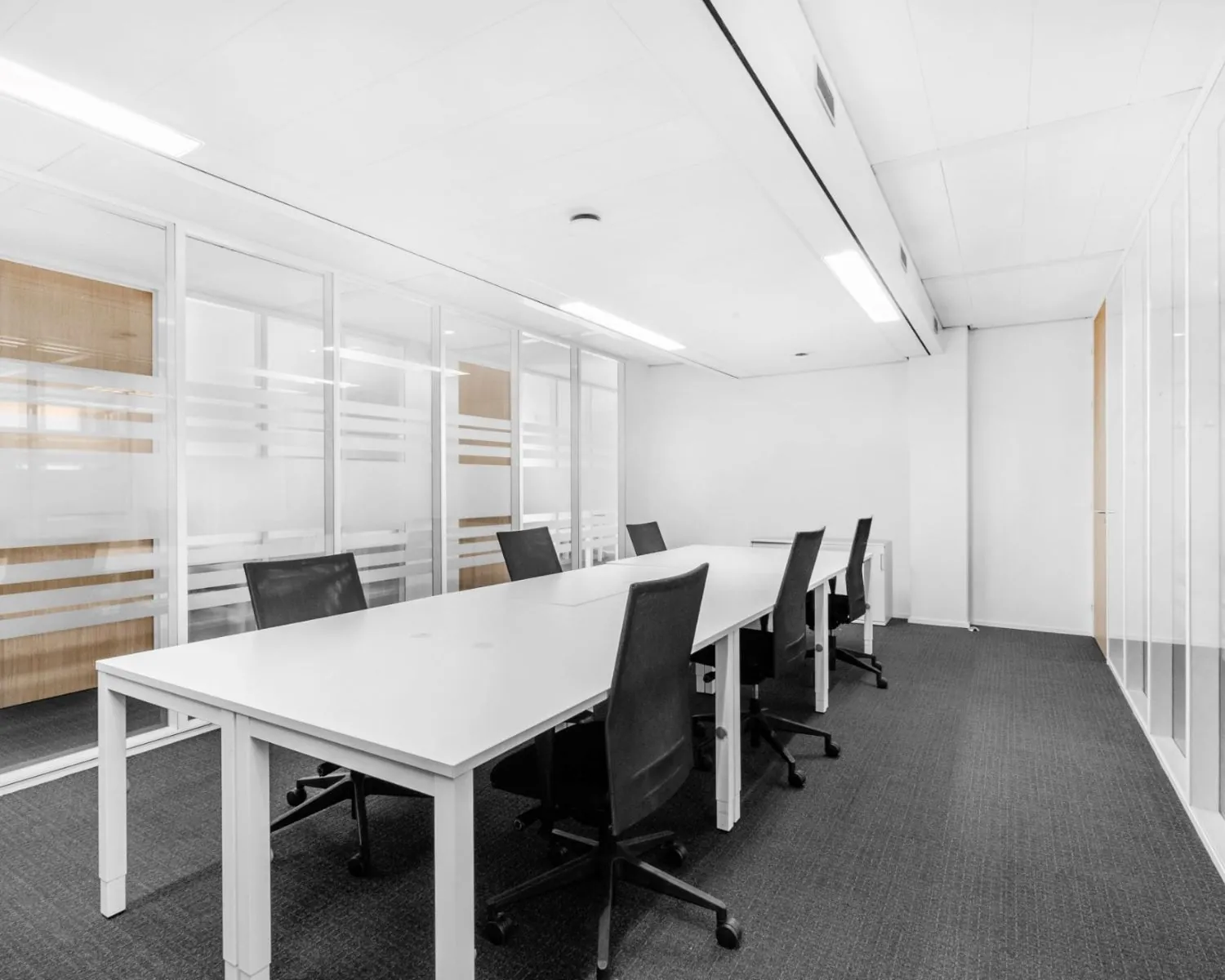 Moderne kantoorruimte met witte bureaus en zwarte stoelen aan de Paterswoldseweg 806.