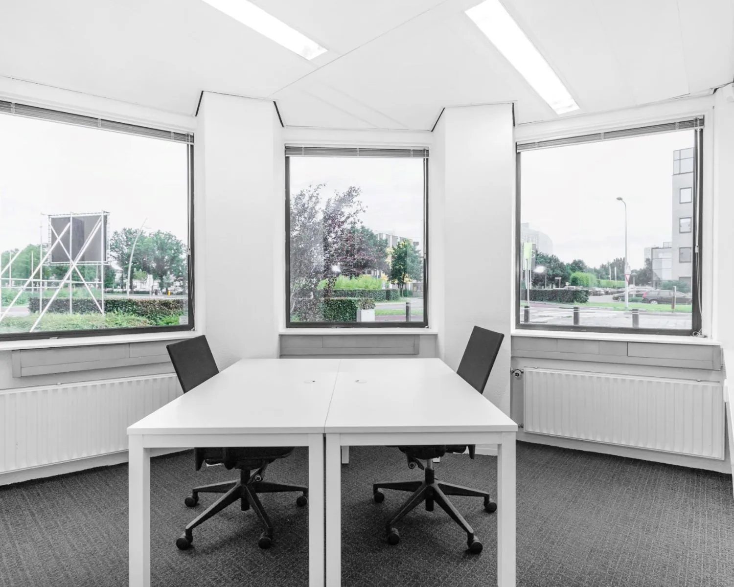 Lichte kantoorruimte met twee bureaus en bureaustoelen aan de Paterswoldseweg in Groningen.