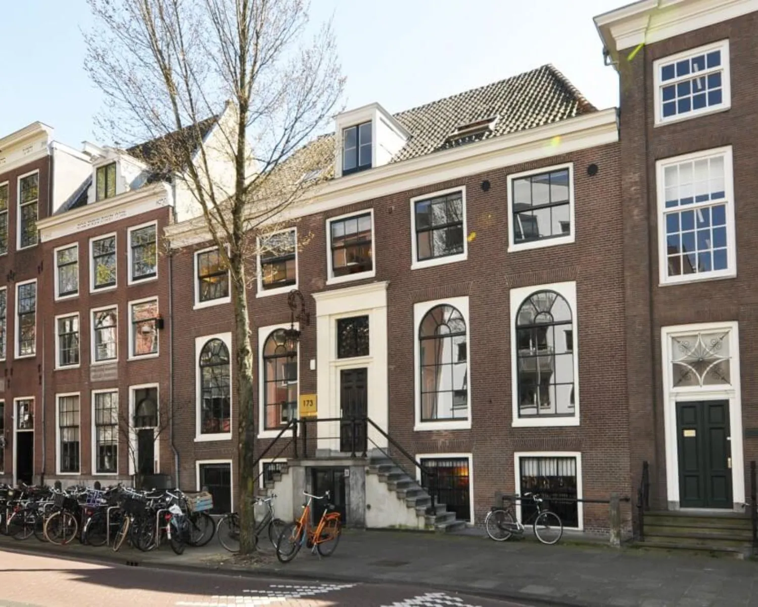 Historisch grachtenpand aan de Rapenburg 173 met meerdere fietsen geparkeerd voor de deur, aangeboden als kantoorruimte te huur.