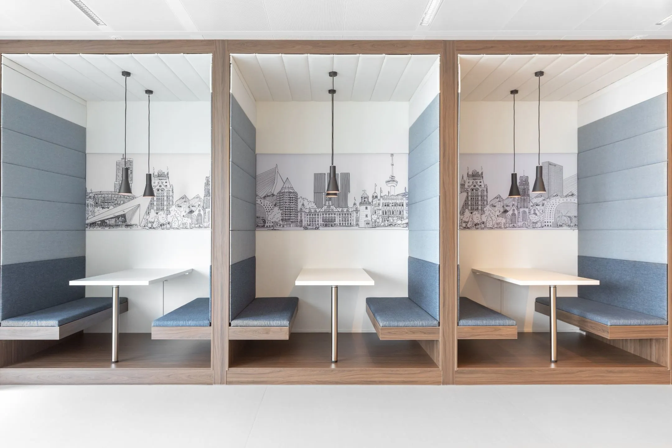 Moderne kantoorruimte met drie gestoffeerde zitnissen en wandschilderingen van de skyline van Rotterdam, Boompjes 40.