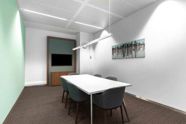 Moderne vergaderruimte in kantoorruimte aan Boompjes 40 in Rotterdam met witte tafel, zes stoelen en wanddecoratie.