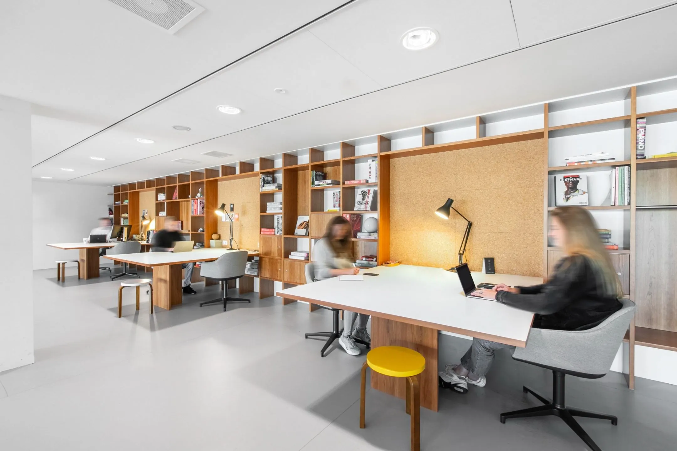 Moderne gedeelde kantoorruimte met werkplekken en open boekenkasten in Rotterdam Hofplein 20.