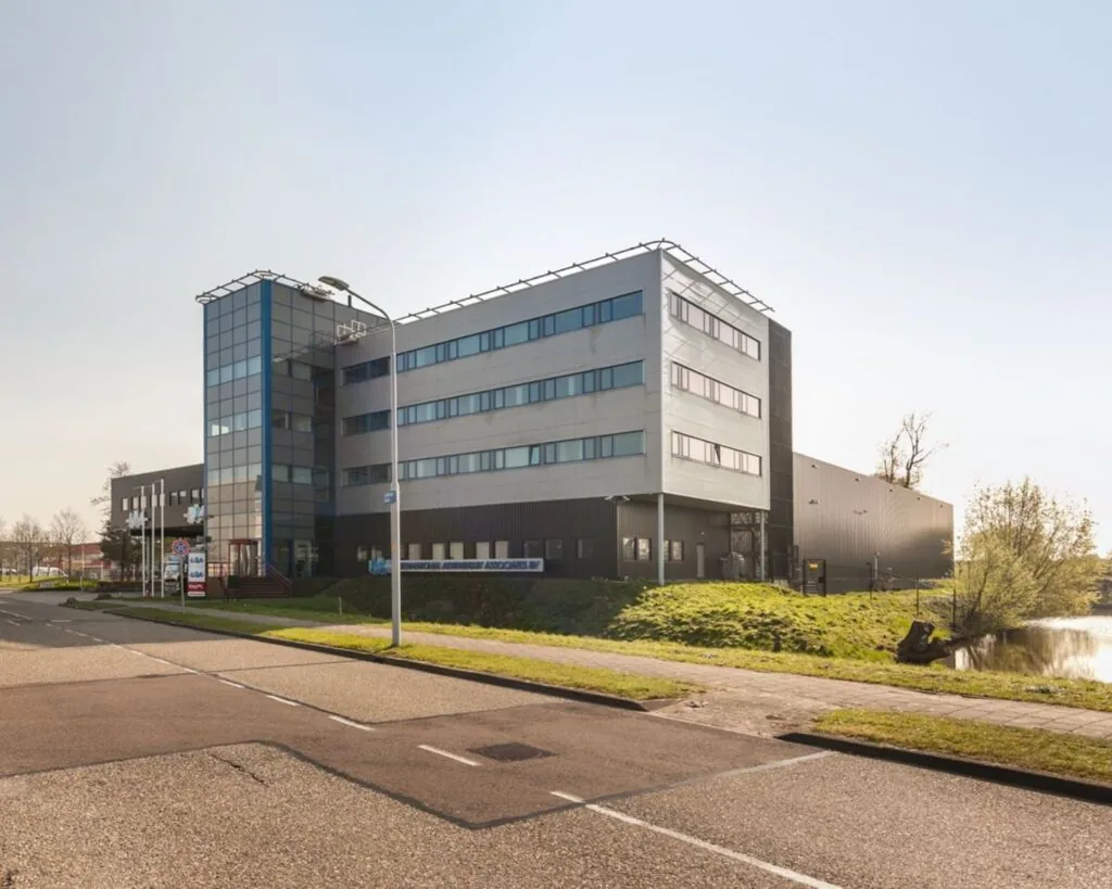 Modern kantoorgebouw aan de Capronilaan 12-20 in Schiphol-Rijk, gelegen naast een waterpartij.