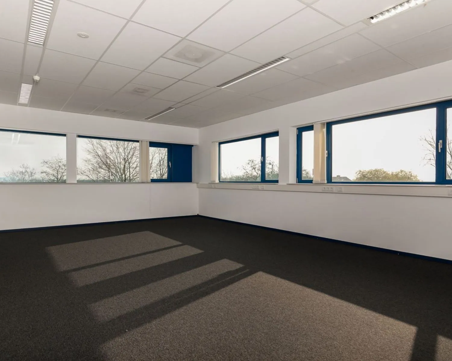 Lichte, lege kantoorruimte met grote ramen aan de Capronilaan in Schiphol-Rijk.