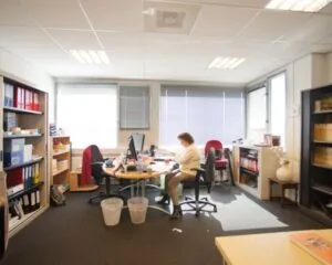 Kantoorruimte aan de Slotermeerlaan 67-3 met bureaus, kasten en een persoon die aan het werk is.