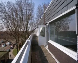 Balkon van een kantoorruimte aan de Slotermeerlaan 67 met uitzicht op bomen en een rustige straat.