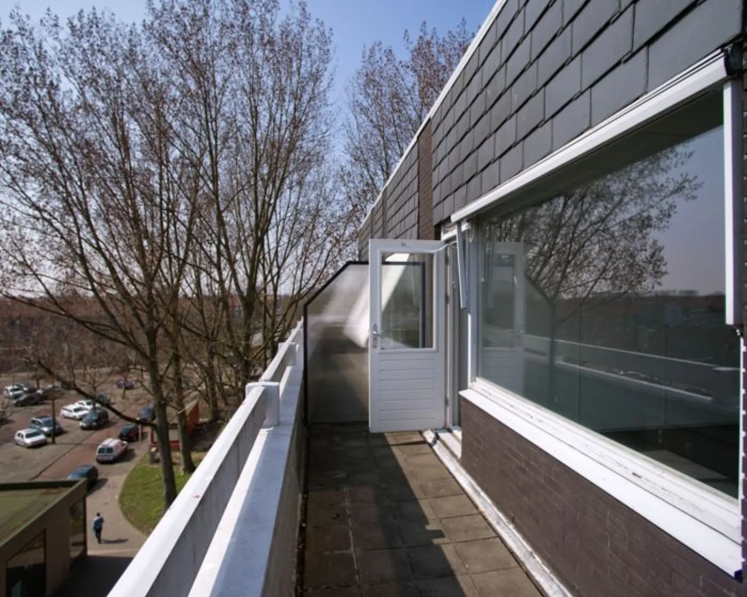 Balkon van een kantoorruimte aan de Slotermeerlaan 67 met uitzicht op bomen en een rustige straat.