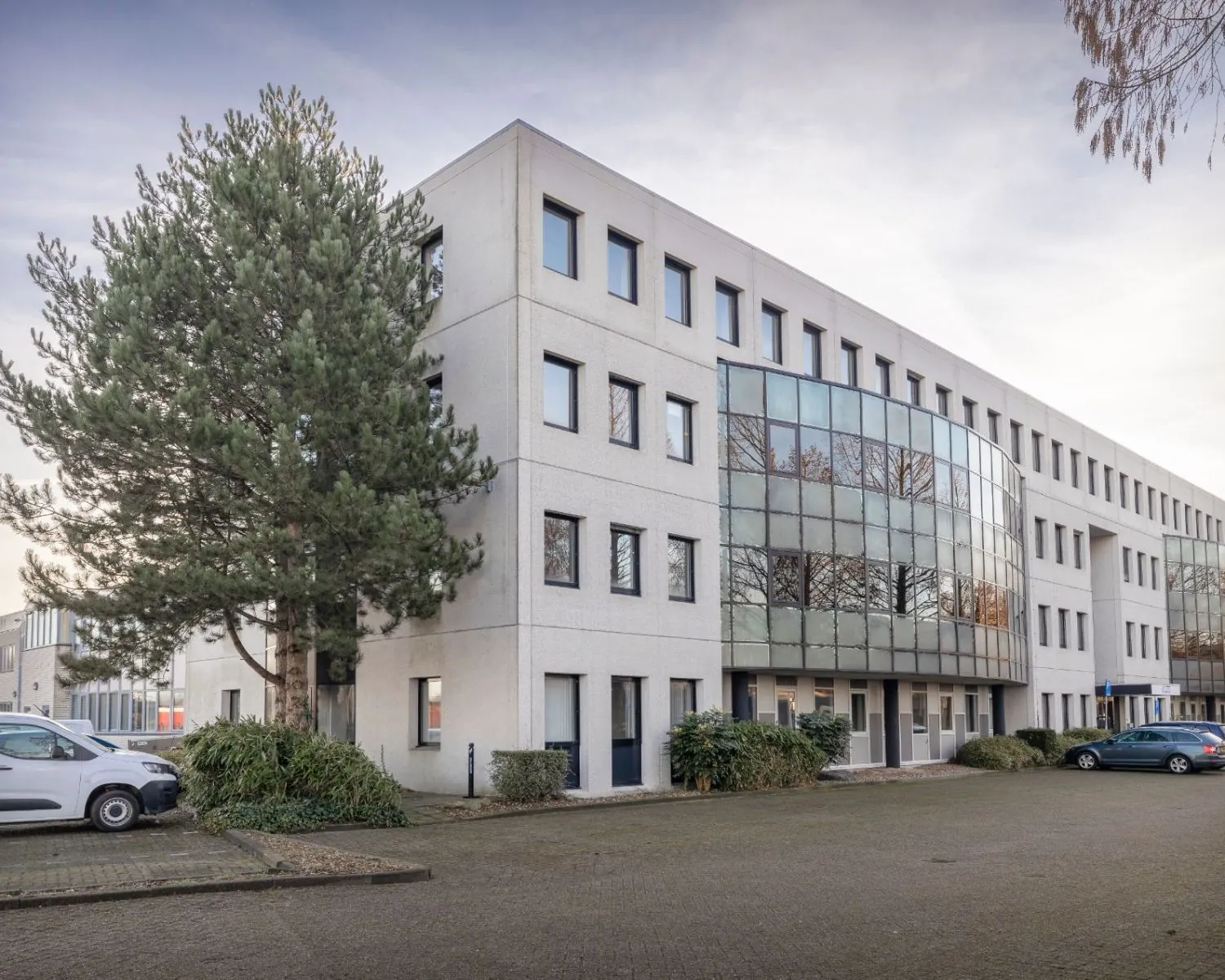 Modern kantoorgebouw aan de Stephensonweg 6-8 met grote ramen en parkeergelegenheid voor de deur.