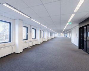 Lichte, ruime kantoorruimte te huur aan de Stephensonweg met meerdere ramen en systeemplafond.