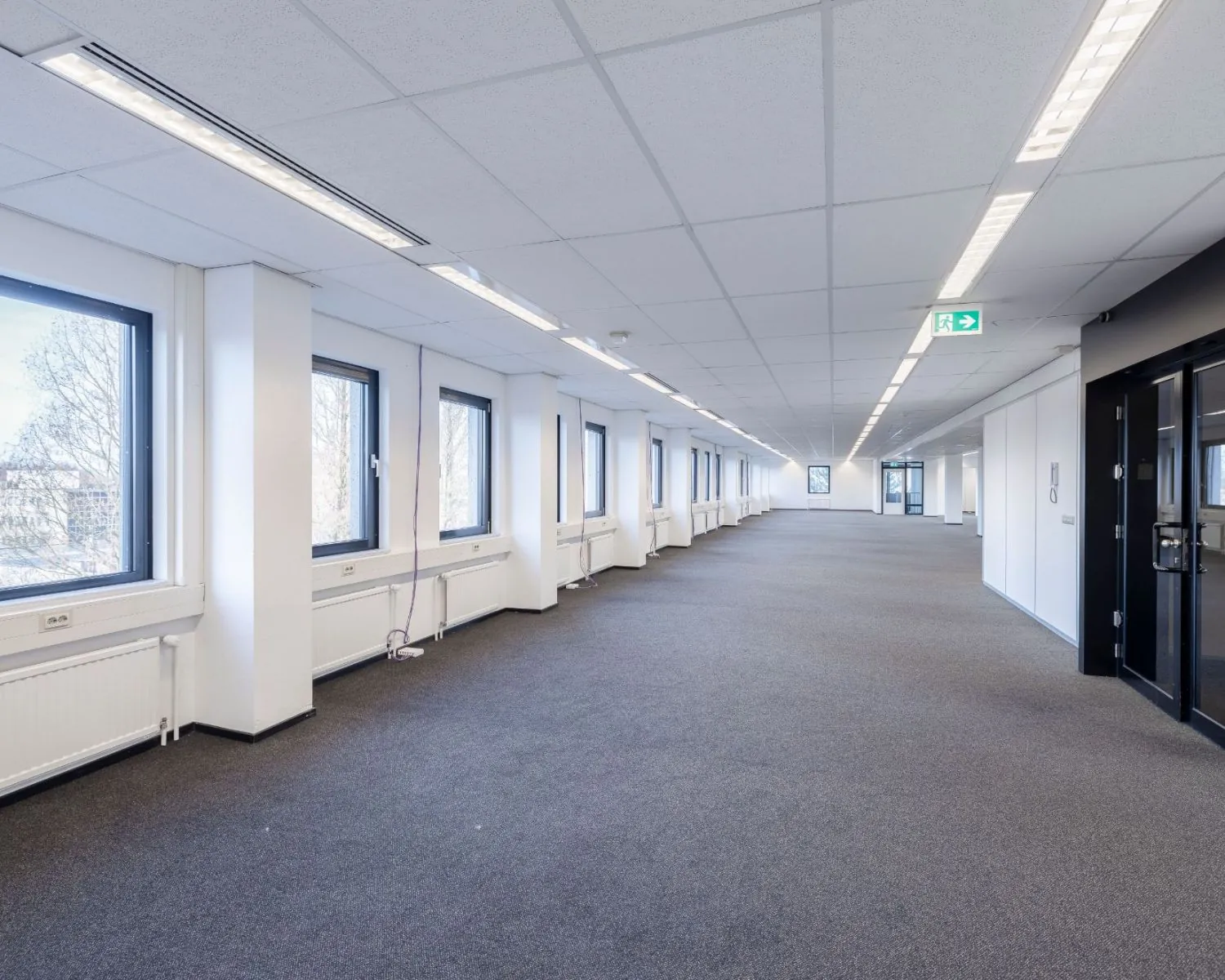 Lichte, ruime kantoorruimte te huur aan de Stephensonweg met meerdere ramen en systeemplafond.