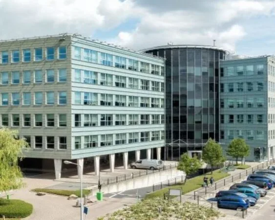 Modern kantoorgebouw aan de Tupolevlaan 2-24 met parkeerplaatsen en groenvoorziening op de voorgrond.