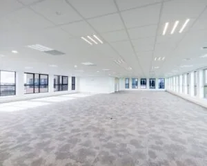 Ruime, lichte kantoorruimte met tapijtvloer en grote ramen aan de Tupolevlaan 2-24.