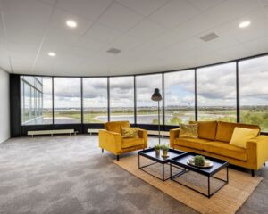 Moderne kantoorruimte aan de Tupolevlaan met gele zitbanken, grote ramen en uitzicht op de omgeving.