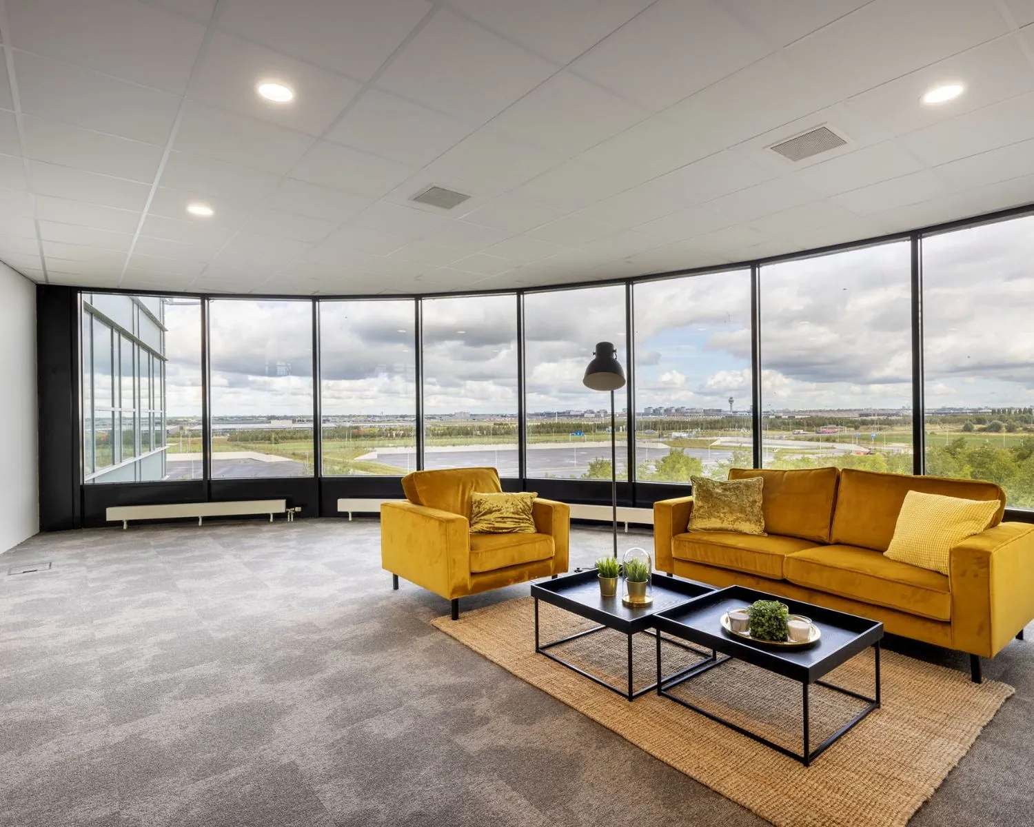 Moderne kantoorruimte aan de Tupolevlaan met gele zitbanken, grote ramen en uitzicht op de omgeving.