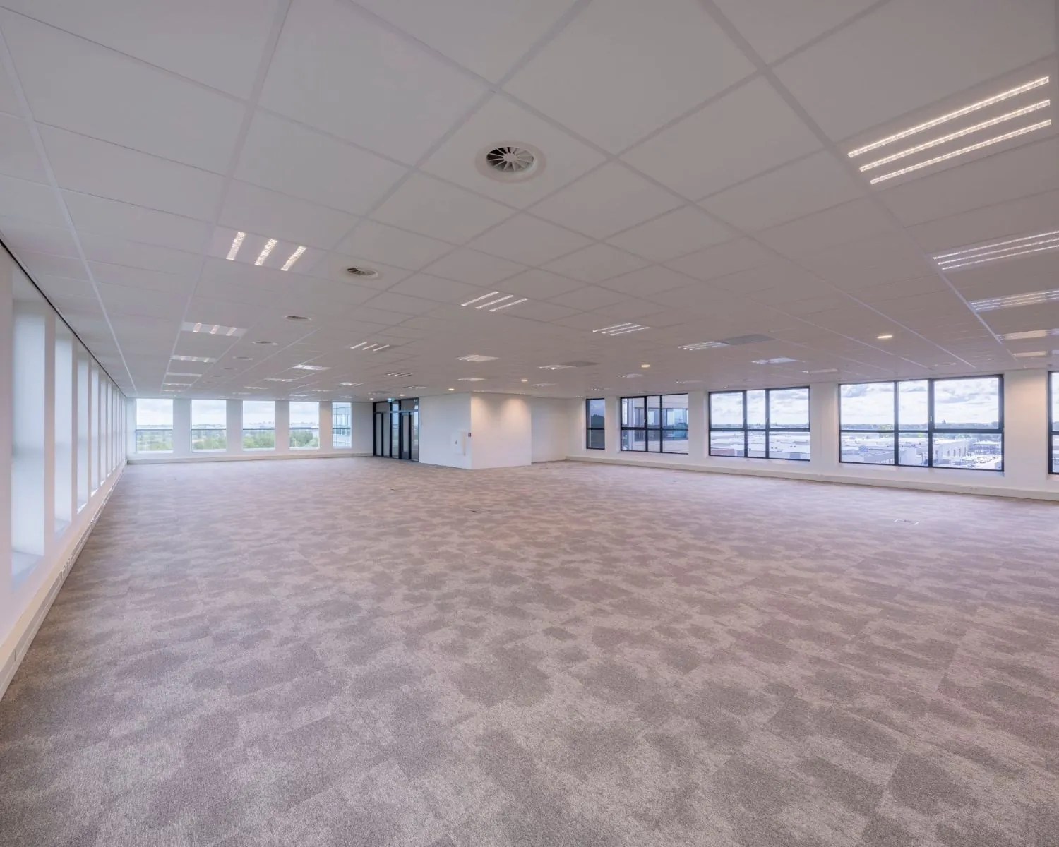 Moderne, lichte en open kantoorruimte te huur aan de Tupolevlaan met grote ramen en systeemplafond.