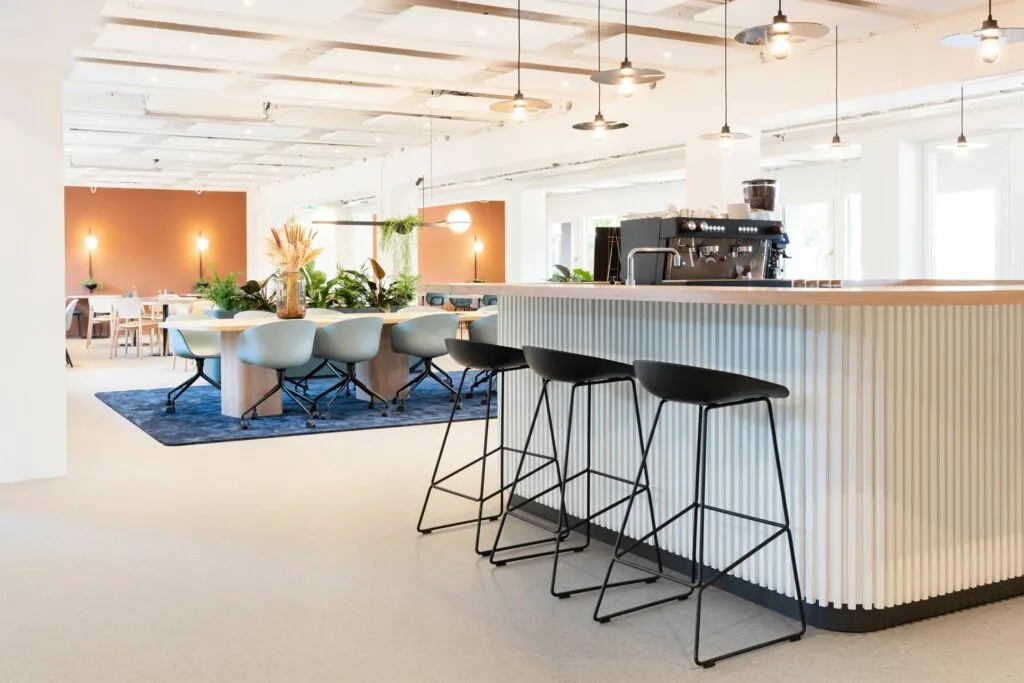 Moderne kantoorruimte met open zithoeken, een koffiebar en vergadertafels aan de Atoomweg 50 in Utrecht.