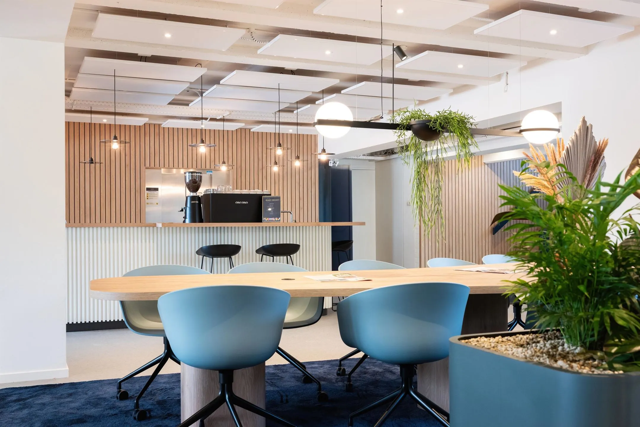 Moderne kantoorruimte aan de Atoomweg 50 in Utrecht met vergadertafel, koffiebar en sfeervolle planten.