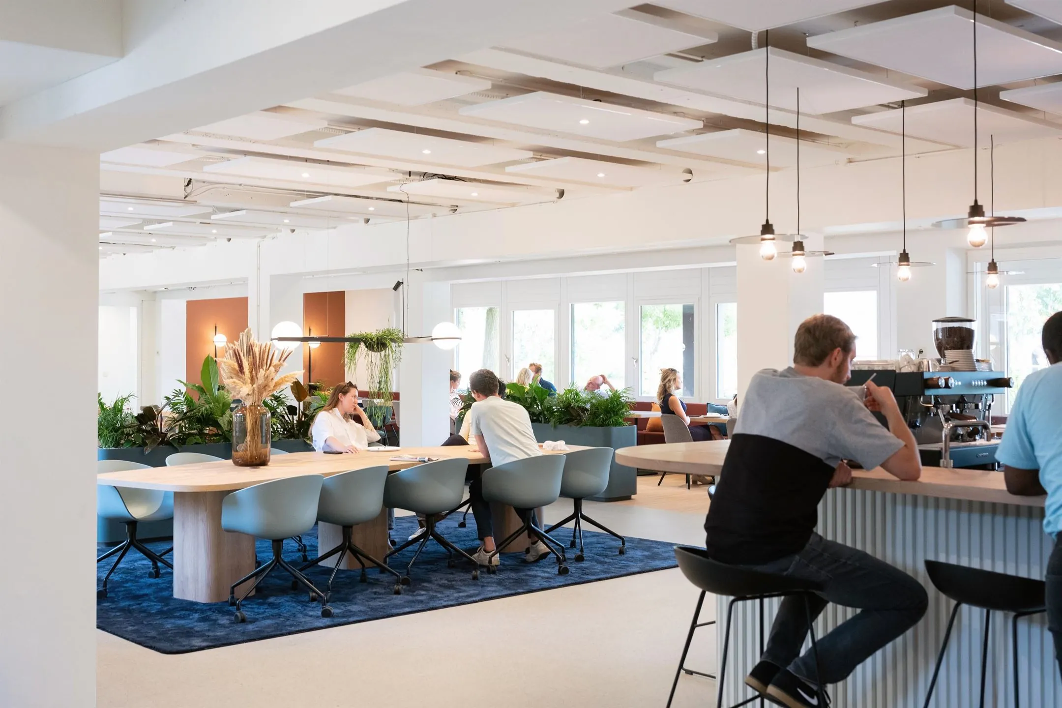 Moderne en lichte kantoorruimte aan de Atoomweg 50 in Utrecht met open werkplekken, zitgedeelte en een koffiebar.