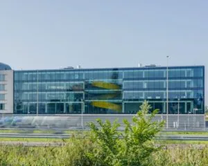 Modern glazen kantoorgebouw aan de Reykjavikstraat in Utrecht met opvallende gele wenteltrap binnenin.