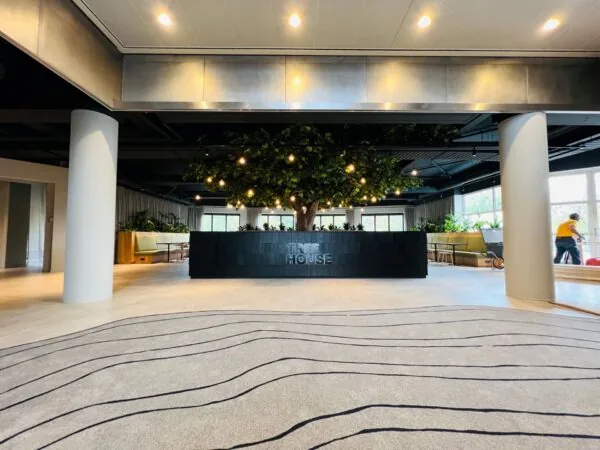 Moderne kantoorlobby aan de Varrolaan 100 in Utrecht met een centrale balie en een boom als blikvanger.