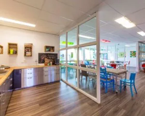 Gezellige en kleurrijke kantoorruimte met open keuken en vergadertafels aan de Waarderweg 19.