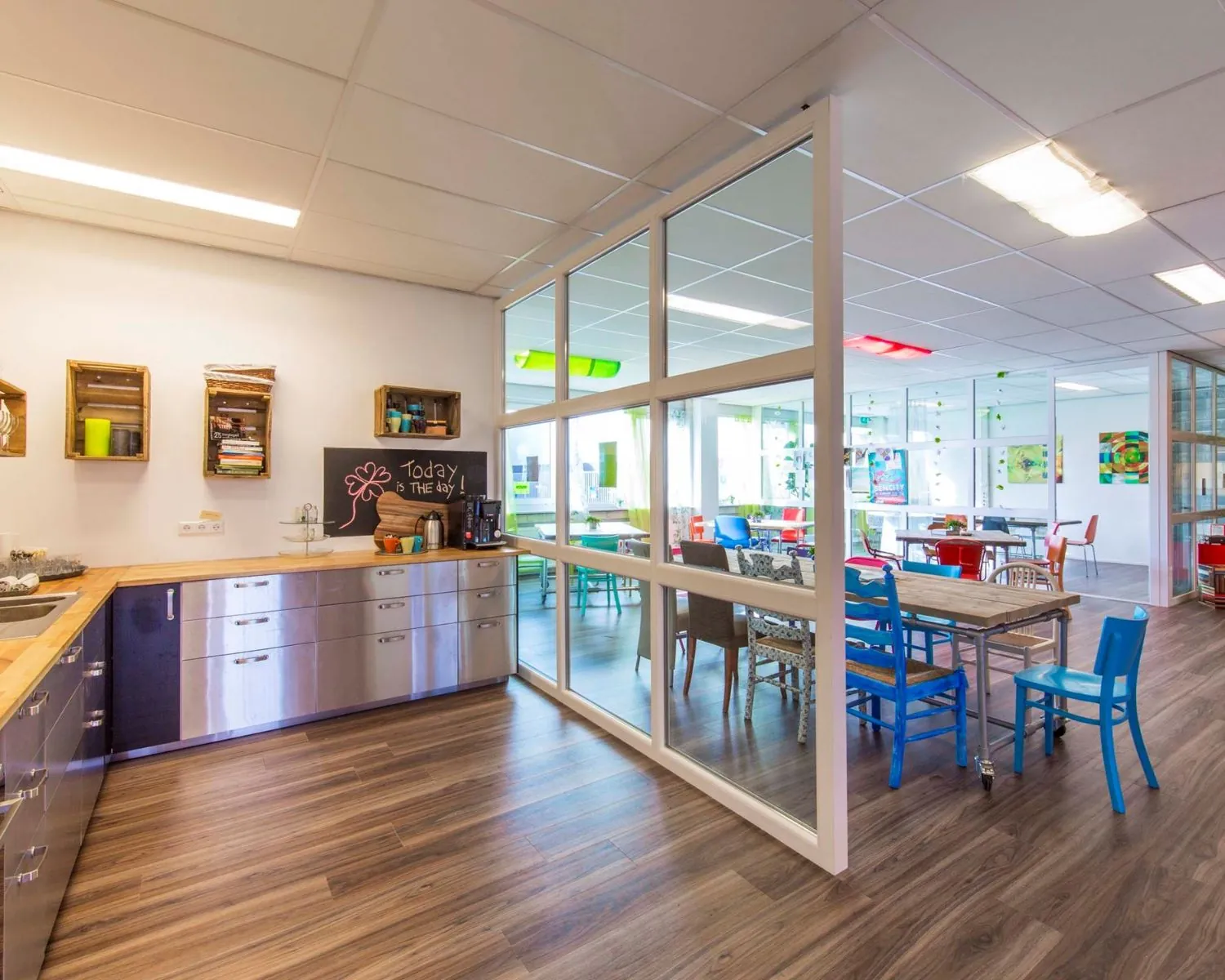 Gezellige en kleurrijke kantoorruimte met open keuken en vergadertafels aan de Waarderweg 19.