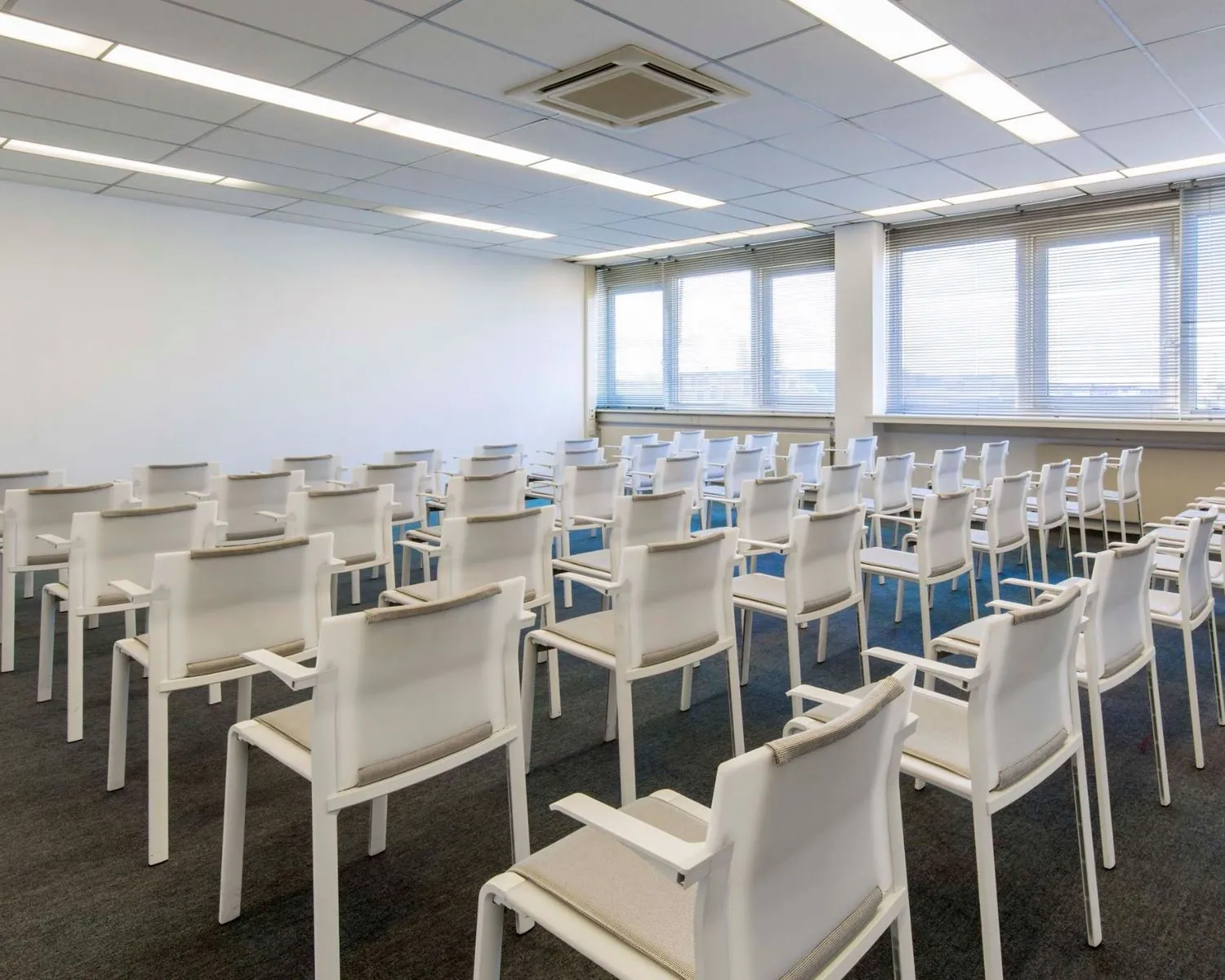 Moderne vergaderruimte met rijen witte stoelen aan de Waarderweg 19.